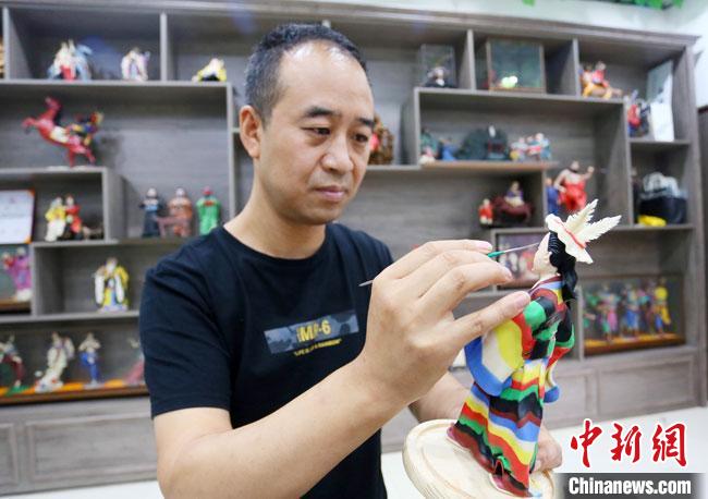 圖為安秋平正在創(chuàng)作代表隴南文縣民俗的《白馬人》作品?！「哒?攝