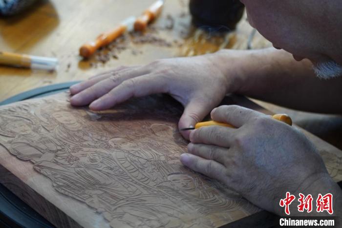 圖為徐晉林湊近木板，近距離制作雕版畫?！【琶赖┰?　攝