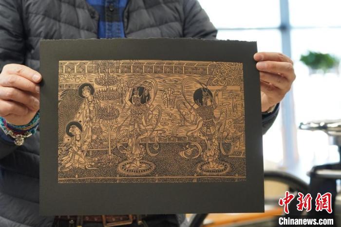 圖為手工書藝人展示敦煌雕版壁畫印刷品?！【琶赖┰?　攝