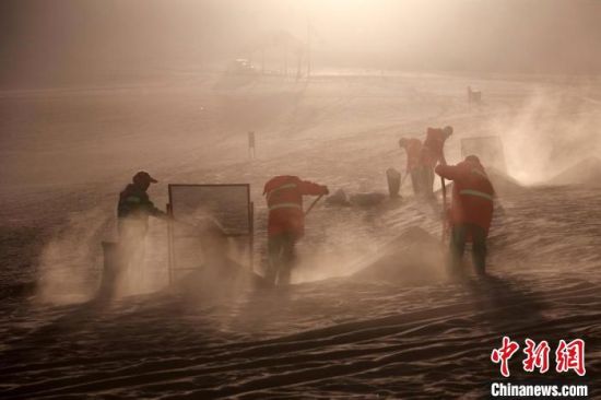 圖為敦煌市鳴沙山月牙泉景區(qū)“駱駝保姆”清理駱駝糞便?！垥粤?攝