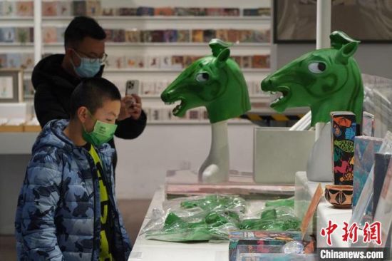 圖為“神馬來了”銅奔馬頭套吸引參觀者駐足?！【琶赖┰?攝