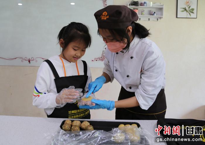 圖為在甘臺(tái)胞小朋友在工作人員指導(dǎo)下制作月餅。九美旦增 攝