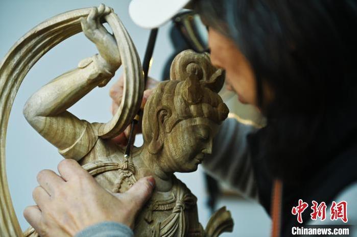 圖為季茂杰進行敦煌元素的木雕創(chuàng)作。李亞龍 攝</p>
<p>