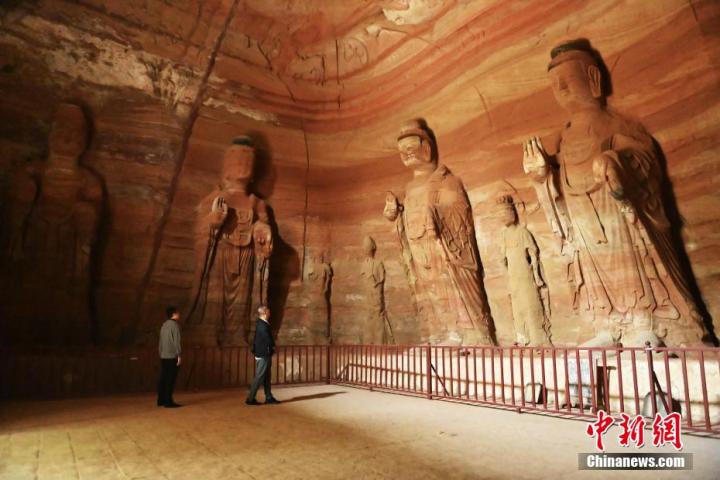 7月15日，游人參觀甘肅省平?jīng)鍪袥艽h百里石窟長廊中的南石窟寺1號窟。百里石窟長廊位于涇川縣境內(nèi)，由512個石窟、5眼窟中石井組成，現(xiàn)存王母宮石窟、鳳凰山石窟、南石窟寺、丈八寺石窟、羅漢洞石窟、太山寺石窟等規(guī)模較大的石窟群，還有數(shù)量眾多的小石窟群。南石窟寺開鑿于北魏永平三年，其中1號窟屬于大型七佛窟，七佛高達6米。中新社記者 李亞龍 攝