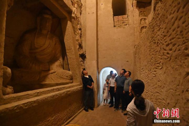 7月15日，游人參觀甘肅省平?jīng)鍪袥艽h百里石窟長廊中的王母宮石窟。百里石窟長廊位于涇川縣境內(nèi)，由512個石窟、5眼窟中石井組成，現(xiàn)存王母宮石窟、鳳凰山石窟、南石窟寺、丈八寺石窟、羅漢洞石窟、太山寺石窟等規(guī)模較大的石窟群，還有數(shù)量眾多的小石窟群。王母宮石窟又名千佛洞，該窟設(shè)計宏大，造像生動，窟內(nèi)擁有造像數(shù)百尊，是較為珍貴的佛教文化歷史遺存。中新社記者 李亞龍 攝</p>
<p>